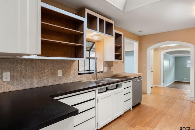 kitchen featuring tasteful backsplash, dishwasher, dark countertops, light wood-type flooring, and open shelves