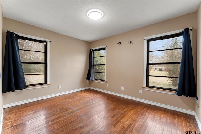 empty room featuring hardwood / wood-style flooring and baseboards