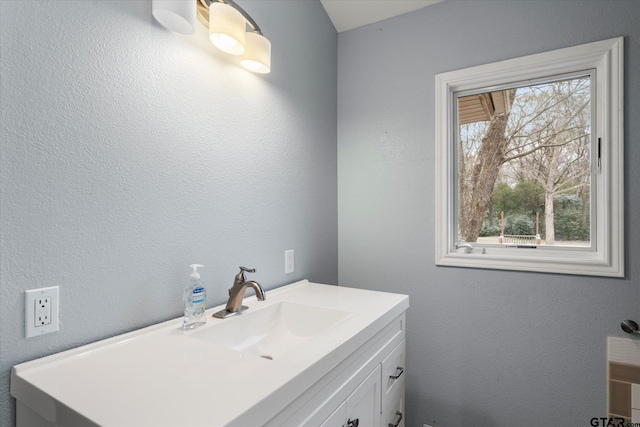 bathroom featuring a textured wall and vanity