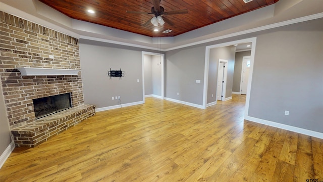 unfurnished living room featuring baseboards, a raised ceiling, hardwood / wood-style floors, ceiling fan, and wood ceiling