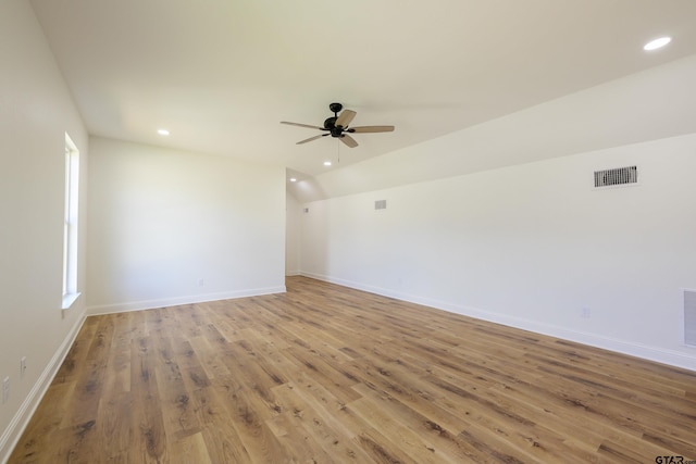 spare room featuring lofted ceiling, recessed lighting, visible vents, wood finished floors, and baseboards