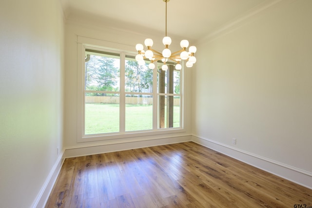 unfurnished dining area with baseboards, wood finished floors, and an inviting chandelier