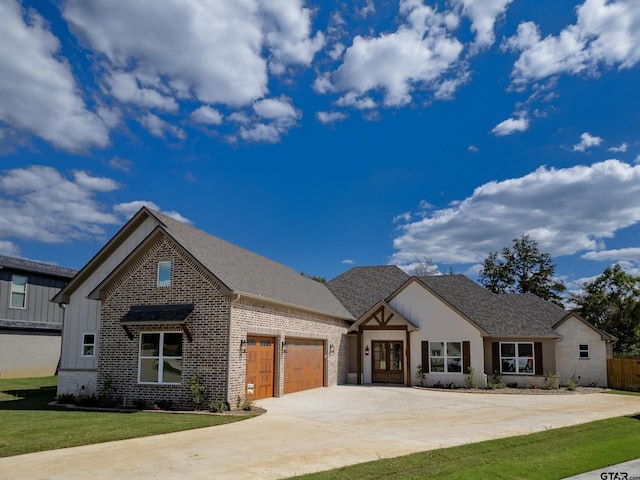 view of front facade with a garage, brick siding, driveway, roof with shingles, and board and batten siding