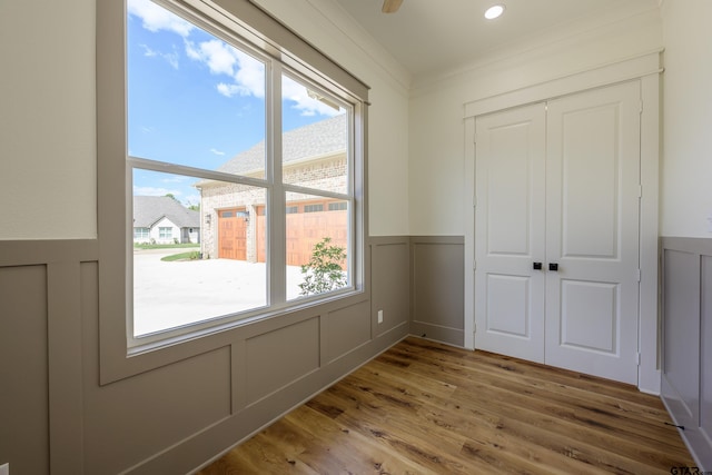 interior space with multiple windows, a decorative wall, and wood finished floors