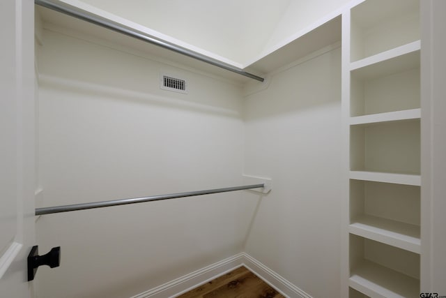 spacious closet featuring visible vents and wood finished floors