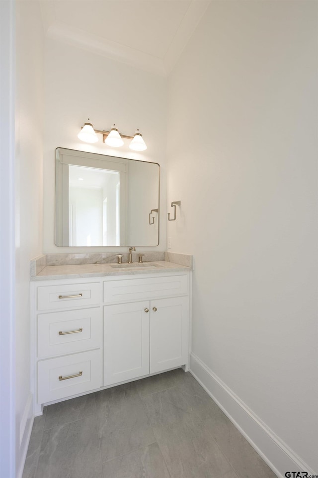 bathroom with ornamental molding, vanity, and baseboards