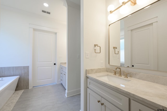 full bath featuring tile patterned flooring, visible vents, a freestanding bath, and vanity