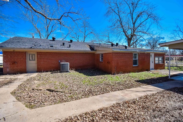 back of property featuring brick siding and cooling unit