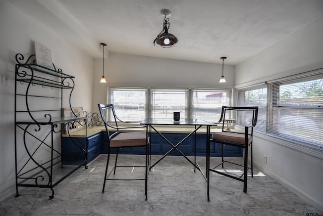 interior space featuring marble finish floor, multiple windows, and baseboards