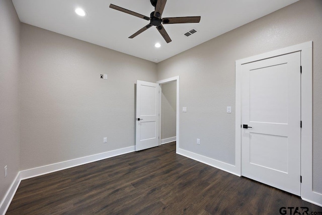 spare room with dark wood-type flooring and ceiling fan