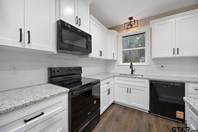 kitchen with dark wood-type flooring, sink, white cabinetry, light stone counters, and black appliances