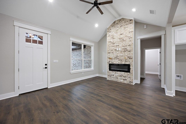 unfurnished living room with dark wood-type flooring, ceiling fan, a fireplace, and lofted ceiling with beams