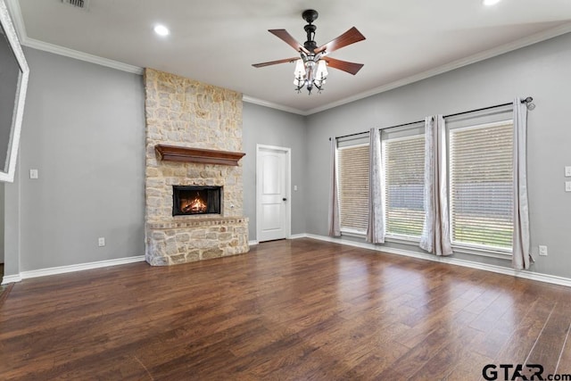 unfurnished living room with dark wood-type flooring, a stone fireplace, ceiling fan, and crown molding