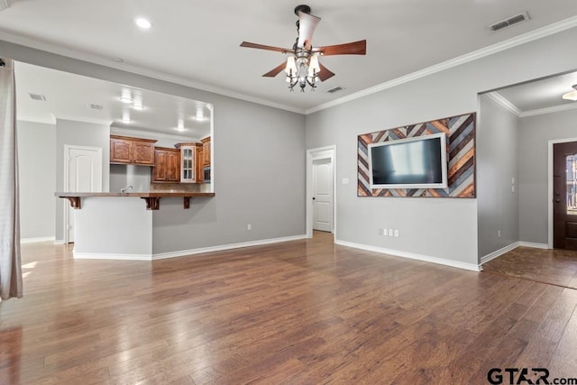 unfurnished living room with dark hardwood / wood-style flooring, ceiling fan, and crown molding