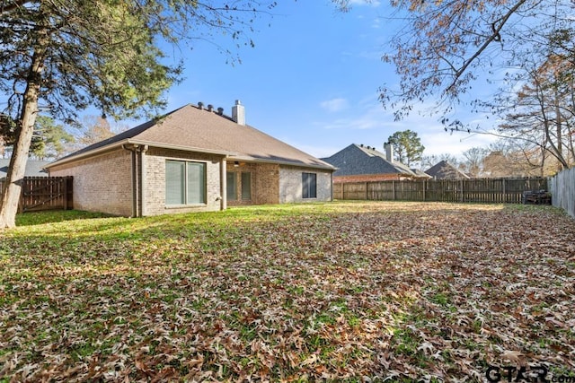 rear view of house featuring a yard