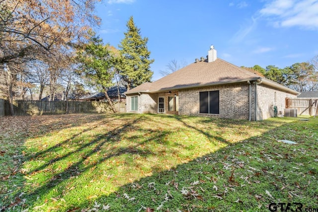 rear view of house with a yard and central AC unit