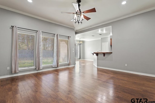 unfurnished living room with ceiling fan with notable chandelier, dark hardwood / wood-style floors, and ornamental molding