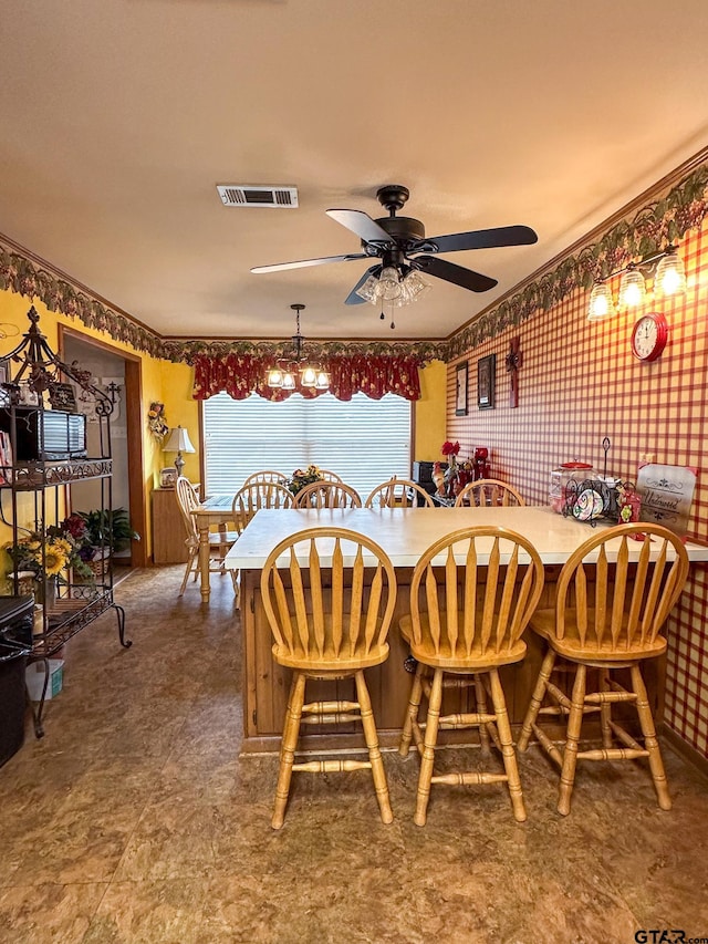 dining room featuring visible vents, wallpapered walls, and ceiling fan