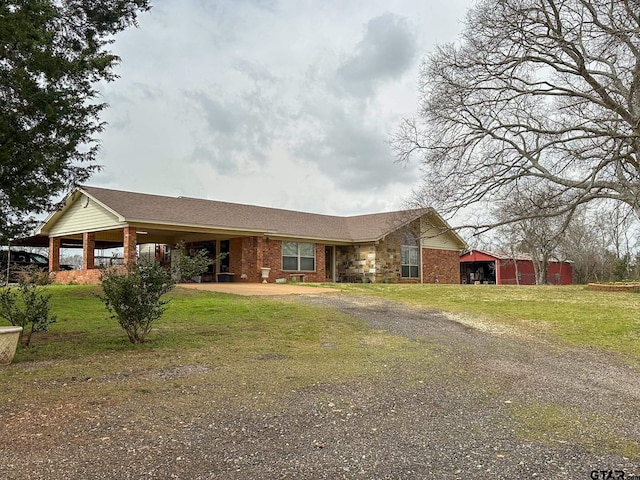 view of front of house with brick siding, an attached carport, driveway, and a front yard