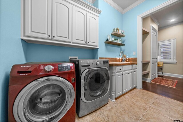 7736 Cross Rd, Tyler, TX 75703 - washroom with ornamental molding, washer and clothes dryer, cabinet space, and light tile patterned flooring
