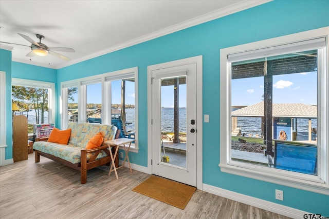 sunroom / solarium with ceiling fan and a water view