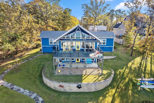 rear view of property featuring a deck, a patio, and a yard