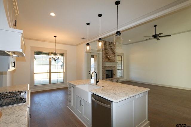 kitchen featuring hanging light fixtures, sink, white cabinets, light stone counters, and stainless steel appliances