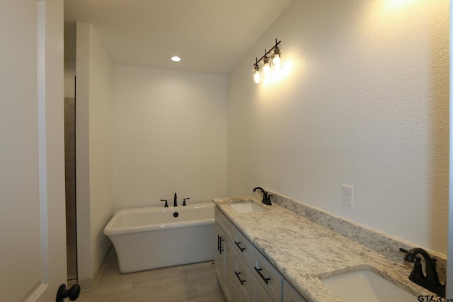 bathroom with vanity, hardwood / wood-style flooring, and a tub