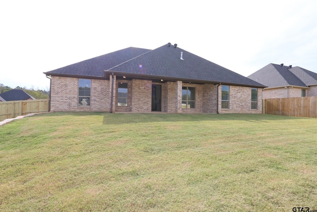 rear view of property featuring a yard