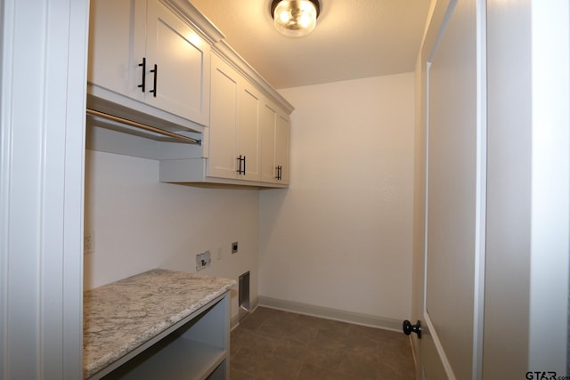 washroom featuring electric dryer hookup and cabinets