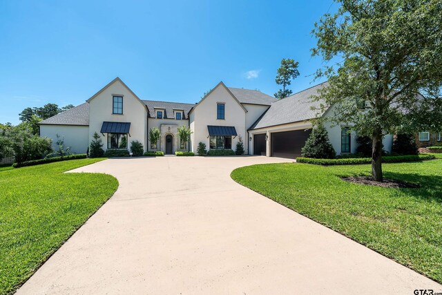 7612 Crosswater, Tyler, TX 75703 - view of front of house with stucco siding, a front yard, an attached garage, and concrete driveway