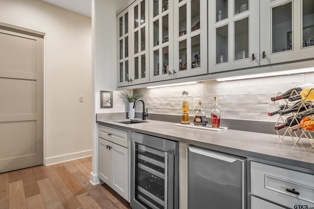 7612 Crosswater, Tyler, TX 75703 - indoor bar with wine cooler, refrigerator, light wood finished floors, and decorative backsplash