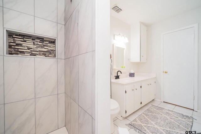 bathroom featuring tile patterned flooring, vanity, and toilet