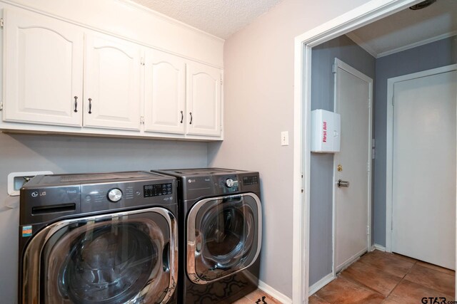 laundry room featuring cabinets, a textured ceiling, washer and clothes dryer, and ornamental molding