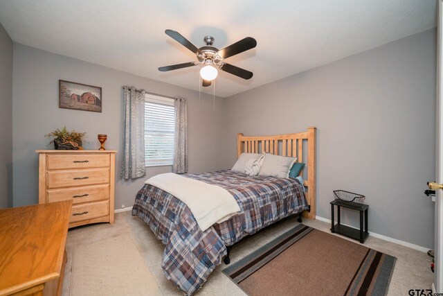 bedroom featuring ceiling fan and light carpet