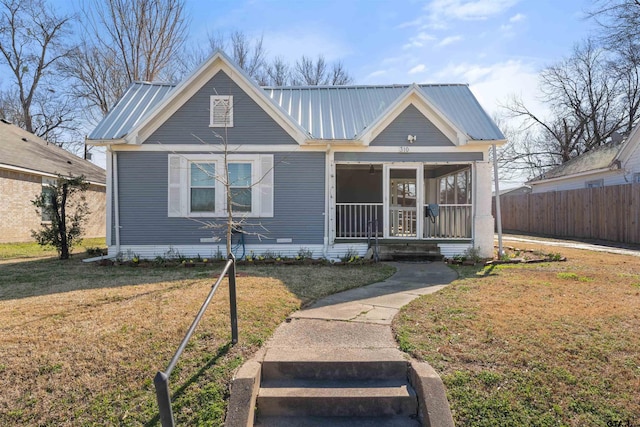 view of front of home featuring crawl space, fence, metal roof, and a front yard