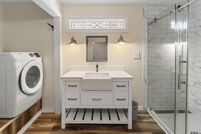 full bathroom featuring wood finished floors, washer / clothes dryer, and a shower stall