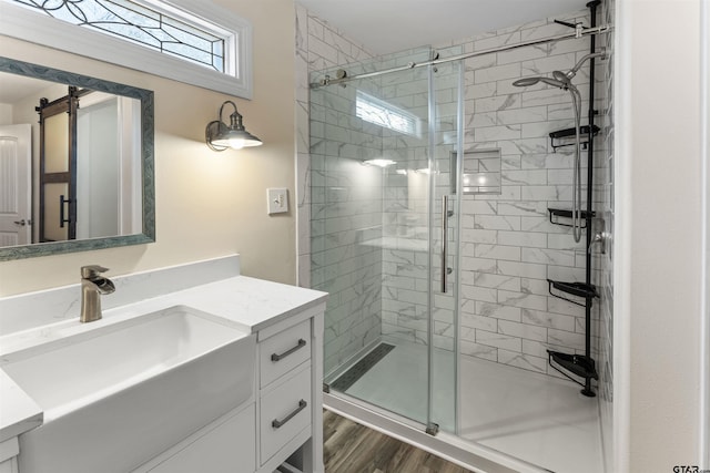 full bath featuring a stall shower, vanity, and wood finished floors