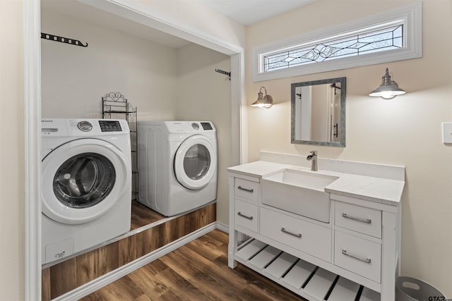 washroom featuring a sink, laundry area, washing machine and dryer, and dark wood finished floors