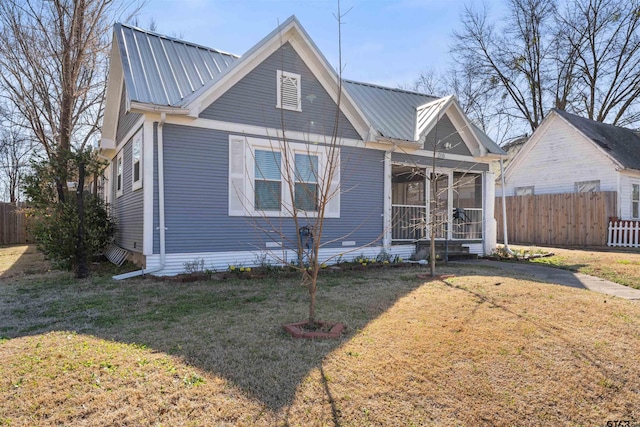 view of front of property featuring metal roof, a front lawn, and fence