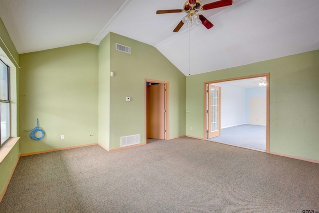 carpeted spare room with a wealth of natural light, ceiling fan, and vaulted ceiling