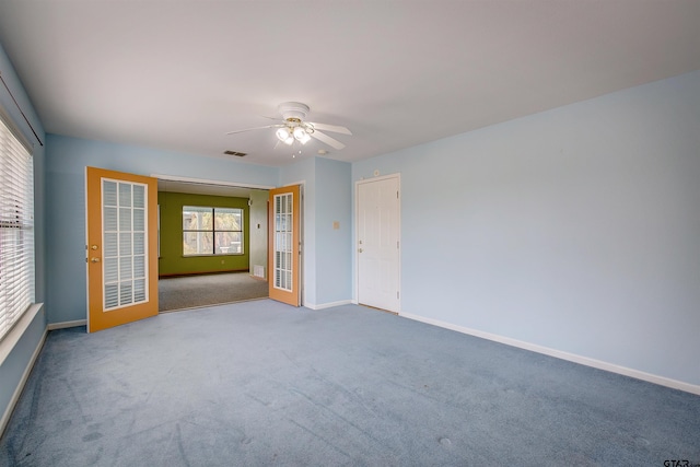 carpeted spare room featuring ceiling fan