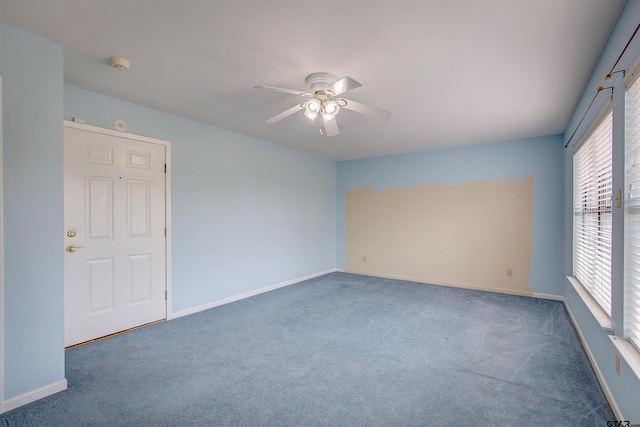 unfurnished room with ceiling fan and dark carpet