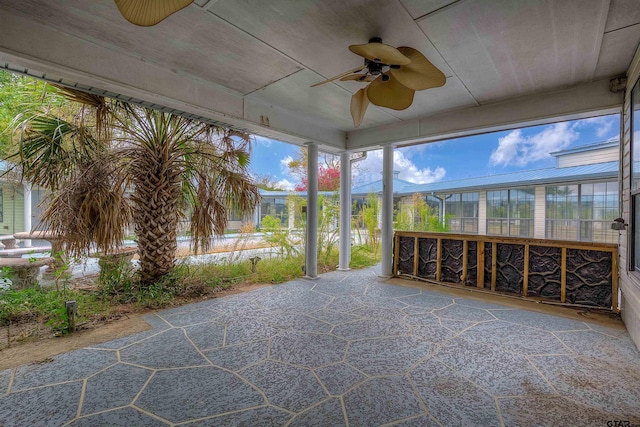 unfurnished sunroom with ceiling fan