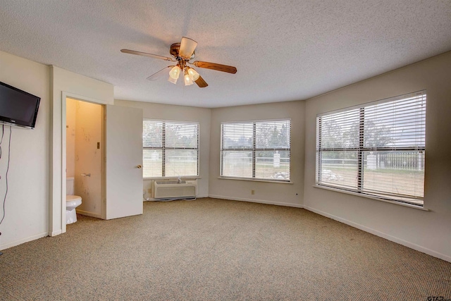 unfurnished bedroom with ensuite bath, ceiling fan, a textured ceiling, cooling unit, and carpet floors