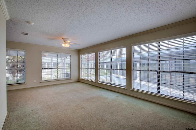 carpeted empty room with ornamental molding, a textured ceiling, and ceiling fan