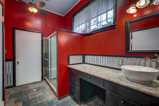 bathroom featuring ornamental molding, walk in shower, ceiling fan, and vanity