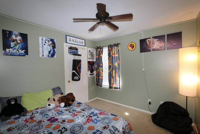 carpeted bedroom featuring baseboards and a ceiling fan