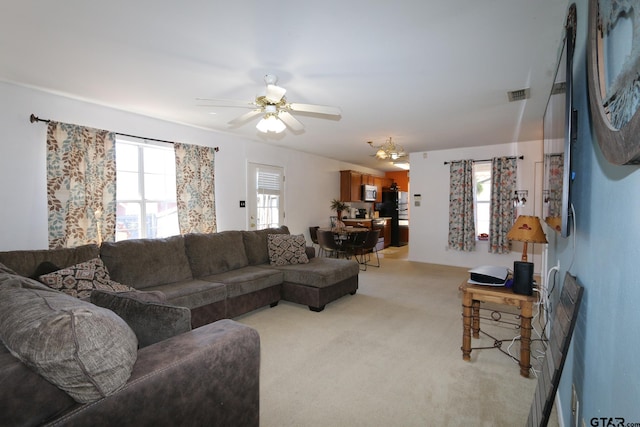 living area with light carpet, ceiling fan, plenty of natural light, and visible vents