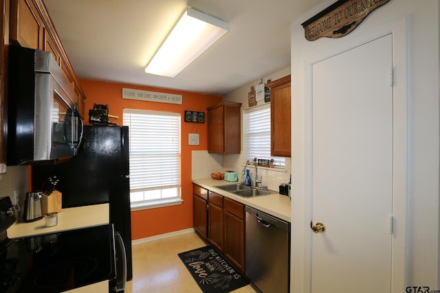 kitchen featuring brown cabinets, stainless steel appliances, light countertops, decorative backsplash, and a sink